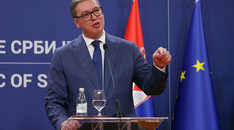 Александар Вучиќ српско знаме прес конференција плава сина позадина облечен кравата бела кошула костим плаво бело сино се заканува со прст гледа поглед кон новинари