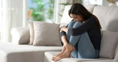 Zamislena devojka sedi doma sofa